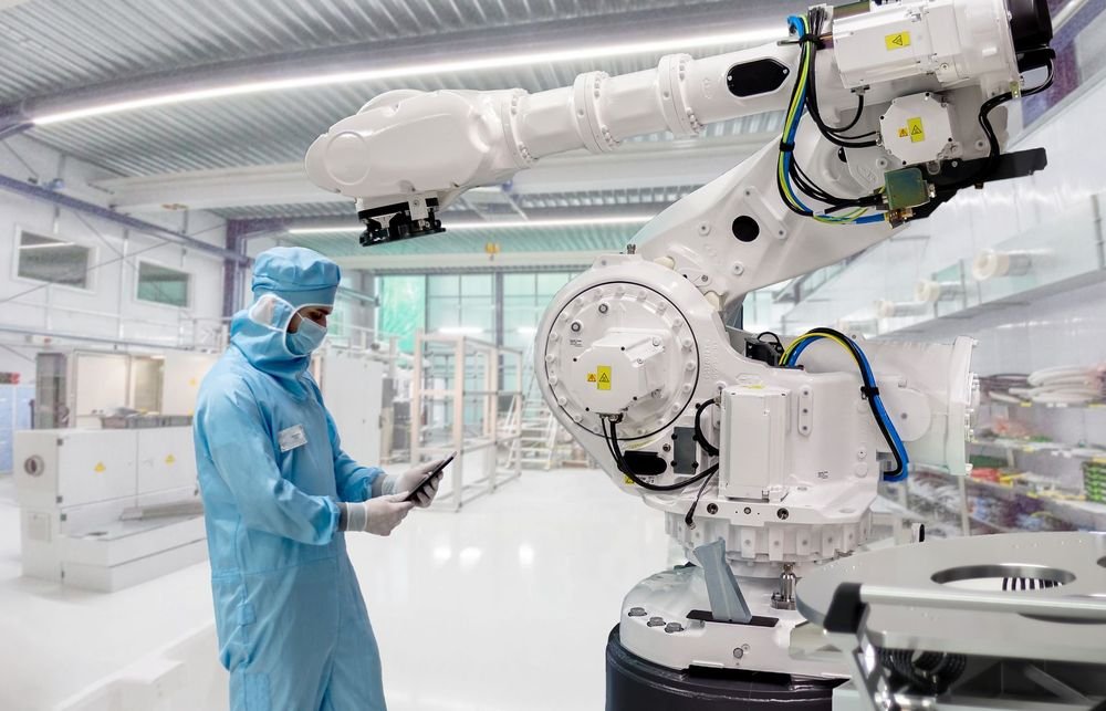 A clean, brightly lit industrial automation facility with enclosed machinery and workstations.